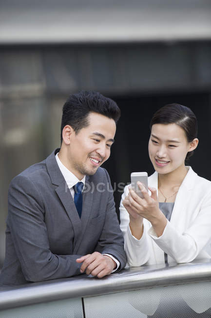 Pessoas de negócios chineses usando smartphone na rua — Fotografia de Stock