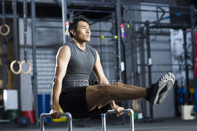 Hombre chino practicando en el gimnasio crossfit - foto de stock