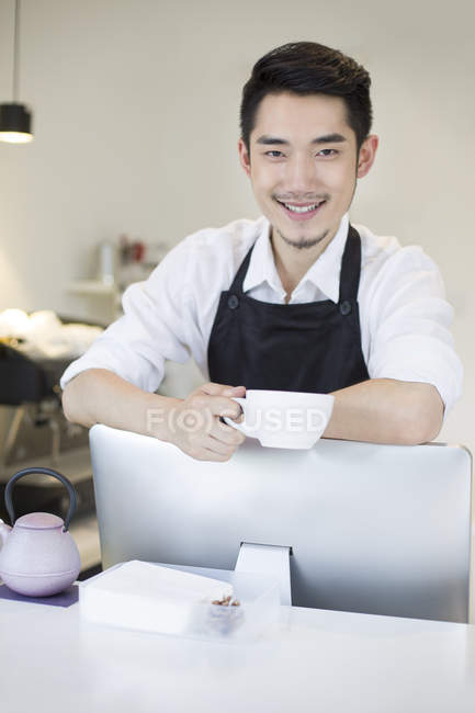 Chinesischer Barista hält Tasse Kaffee — Stockfoto
