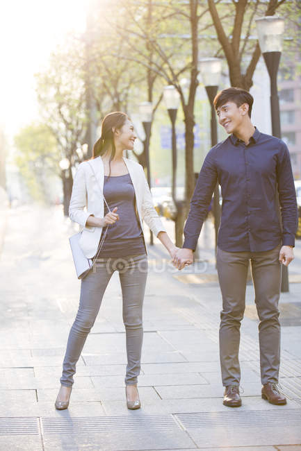 Китайська пара, стоячи на вулиці і тримаючись за руки — стокове фото