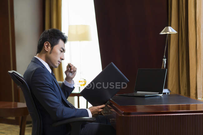 Hombre de negocios chino que trabaja en casa oficina - foto de stock