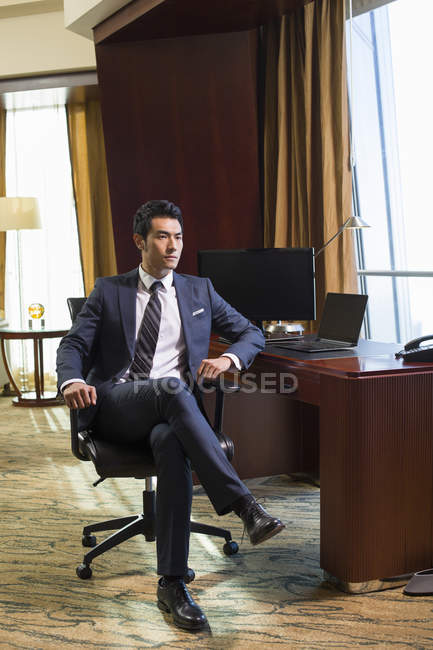 Chinese businessman sitting in home office — Stock Photo