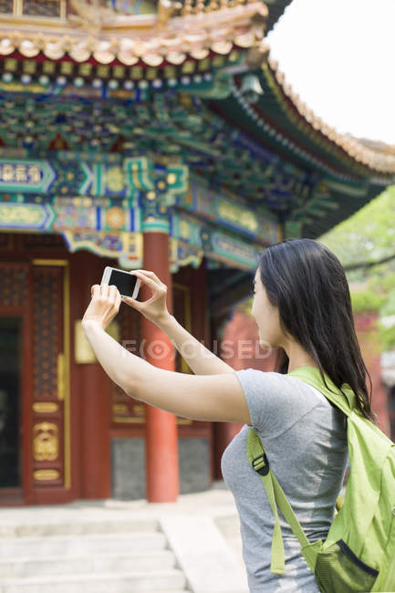 Chinese woman taking pictures with smartphone at Lama Temple — Stock Photo
