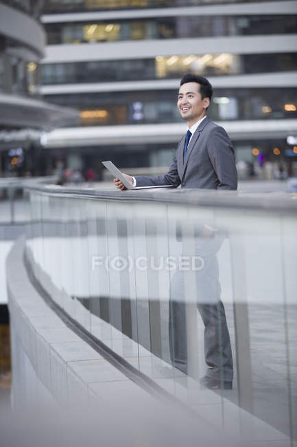 Homme d'affaires chinois utilisant un ordinateur portable dans la rue — Photo de stock