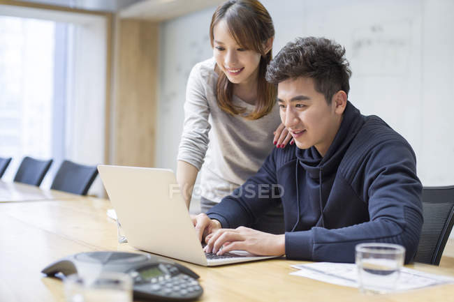 Chinese business people using laptop in board room — Stock Photo