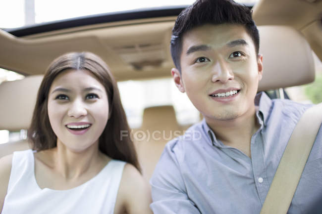 Vista de cerca de la pareja china sentada en el coche - foto de stock