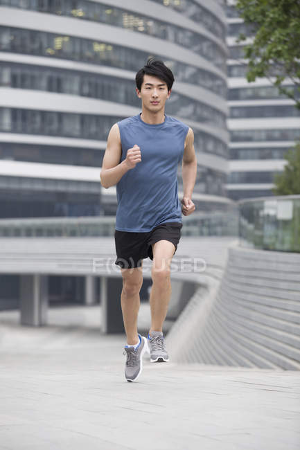 Hombre chino corriendo en la calle - foto de stock