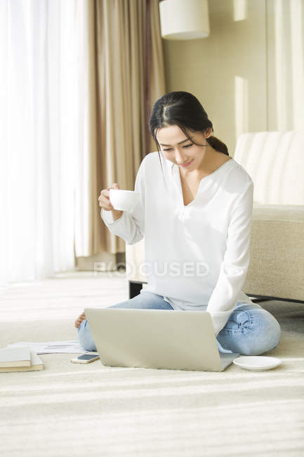 Chinese woman using laptop at home — Stock Photo