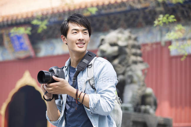 Uomo cinese in visita al Tempio Lama con fotocamera digitale — Foto stock