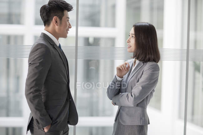 Китайские бизнесмены разговаривают в офисном здании — стоковое фото