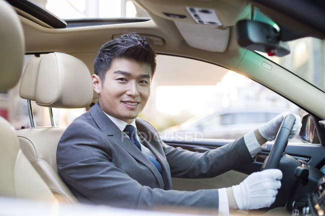Китайська водій, сидячи в машині і посміхається — стокове фото