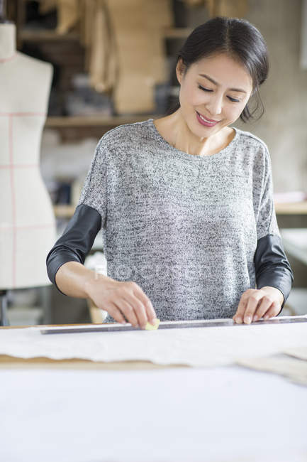Chinese fashion designer working in atelier — Stock Photo
