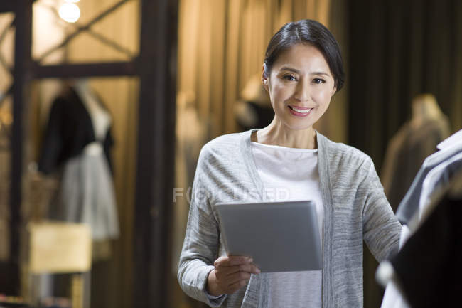 Chinesischer Bekleidungshändler steht mit digitalem Tablet da — Stockfoto