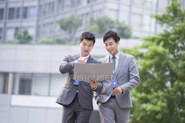 Des hommes d'affaires chinois travaillant avec des documents dans la rue — Photo de stock