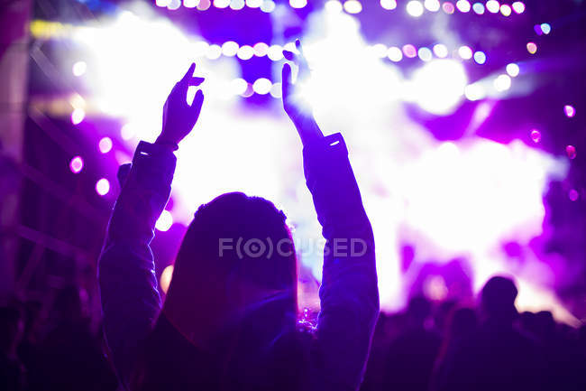 Mujer con brazos levantados en el festival de música - foto de stock