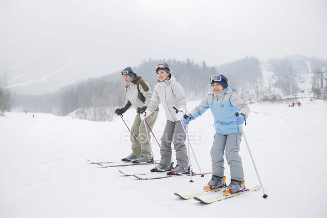 Китайські родини з сином, катання на лижах на гірськолижному курорті — стокове фото