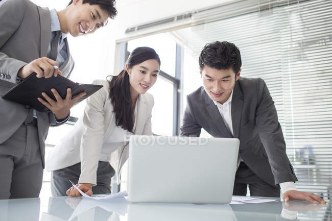 Chinese business person using laptop in meeting — Stock Photo