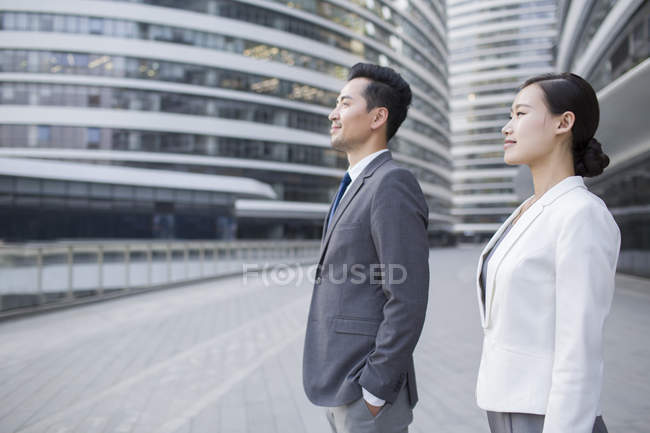Chinese business people looking at view in financial district — Stock Photo