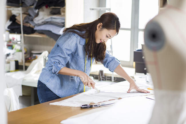 Chinese fashion designer working in studio — Stock Photo