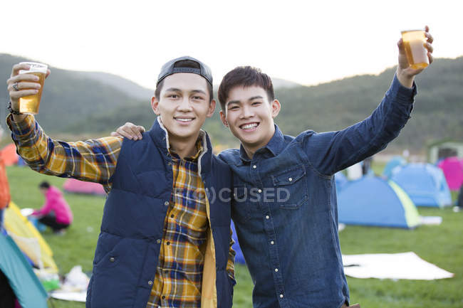 Chinese men posing with beer at festival camping — Stock Photo