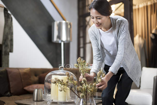 Mature Chinese woman arranging flowers in boutique — Stock Photo