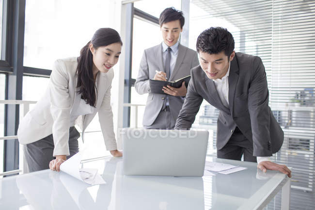 Chinese business people using laptop in meeting — Stock Photo