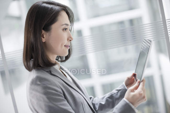 Femme d'affaires chinoise utilisant une tablette numérique — Photo de stock