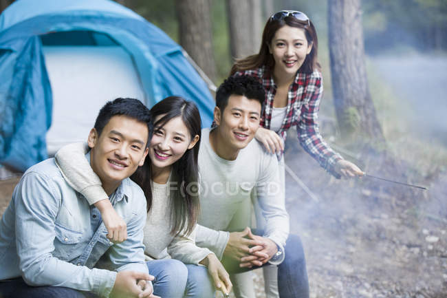 Chinese friends camping in forest — Stock Photo