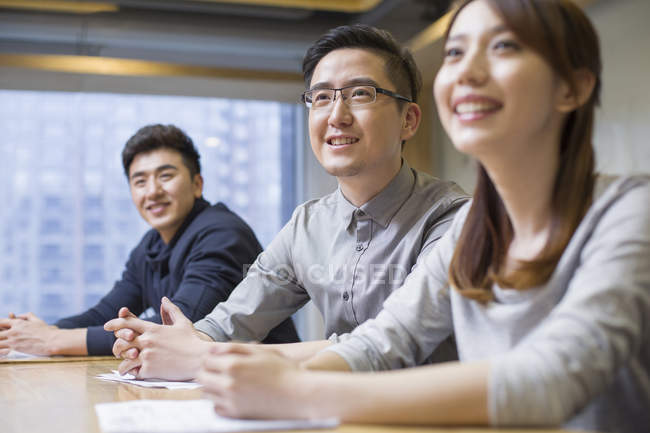 Chinese colleagues sitting at meeting in board room — Stock Photo