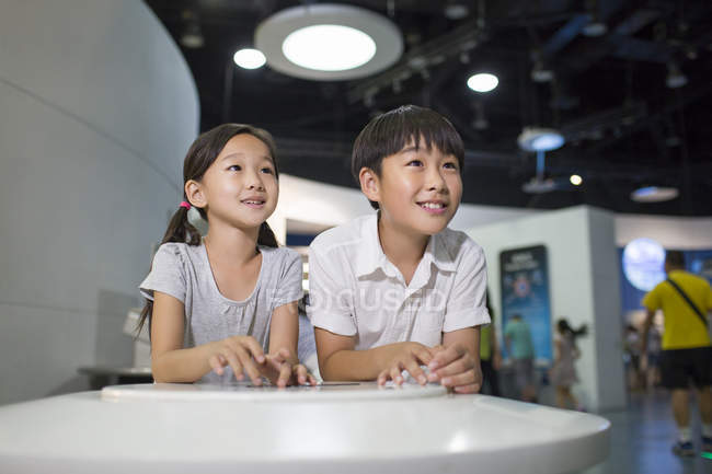 Crianças chinesas sentadas à mesa no museu — Fotografia de Stock