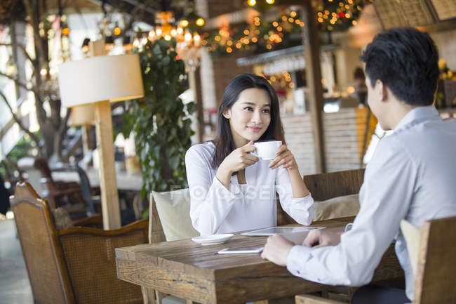 Chinese woman and man sitting in cafe together — Stock Photo
