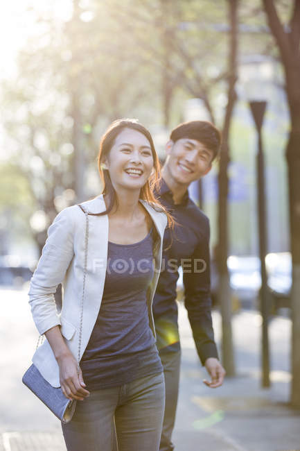 Китайська пара, тримаючись за руки під час прогулянки по тротуару — стокове фото