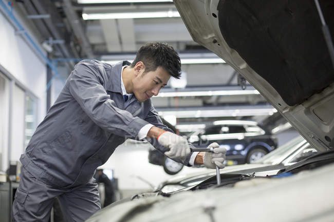 Китайский автомеханик работает в ремонтной мастерской — стоковое фото