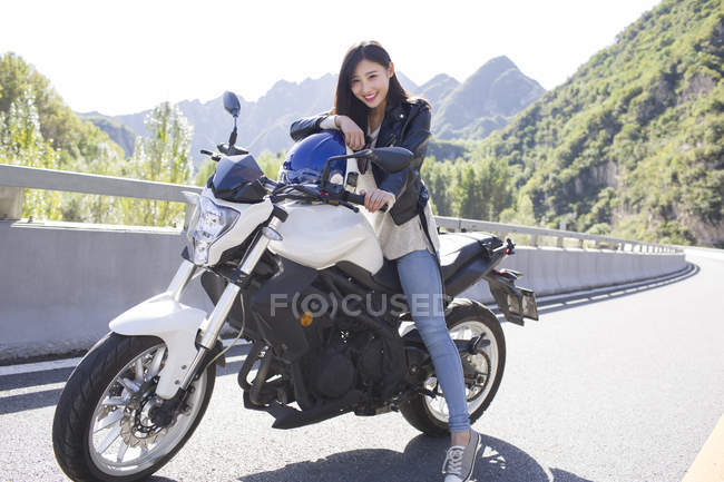 Donna cinese seduta su moto con casco — Foto stock