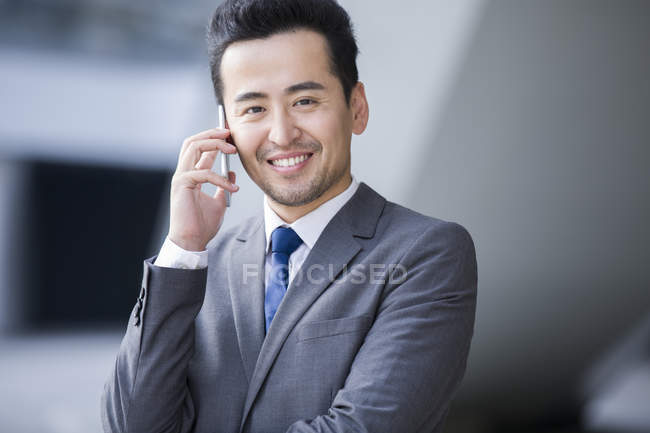 Chinesischer Geschäftsmann telefoniert und lächelt — Stockfoto