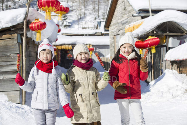Chinese children holding candied haws and looking in camera — Stock Photo