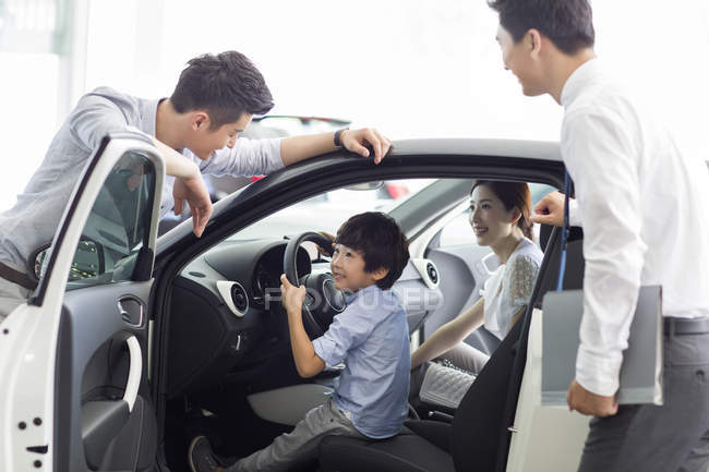 Famiglia cinese con figlio che sceglie auto con rivenditore — Foto stock