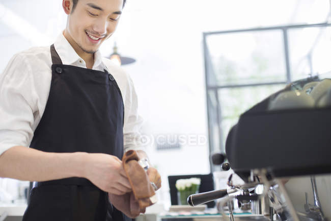 Chinês barista limpeza aparelho no café — Fotografia de Stock