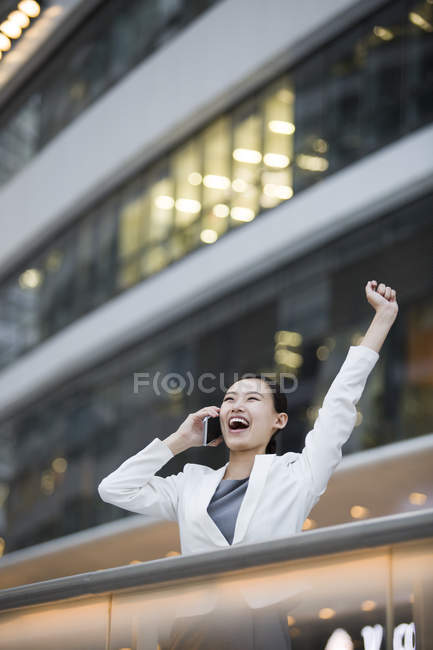 Empresária chinesa falando ao telefone e aplaudindo — Fotografia de Stock