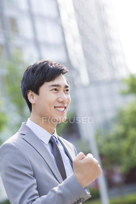 Chinese businessman cheering on street — Stock Photo
