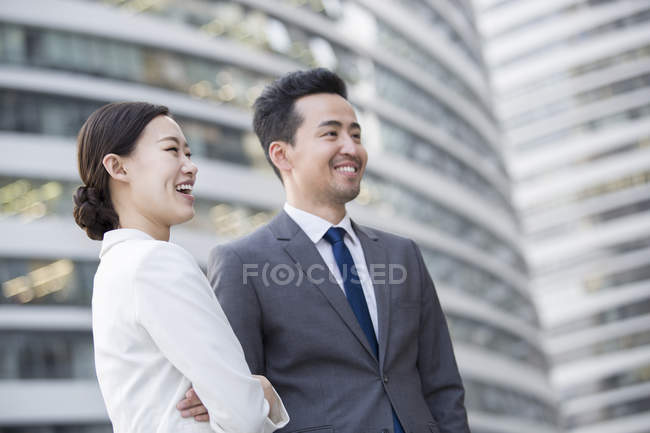 Chinese business people looking at view and smiling — Stock Photo