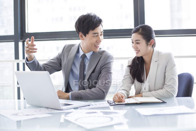 Les hommes d'affaires chinois utilisant un ordinateur portable en réunion — Photo de stock