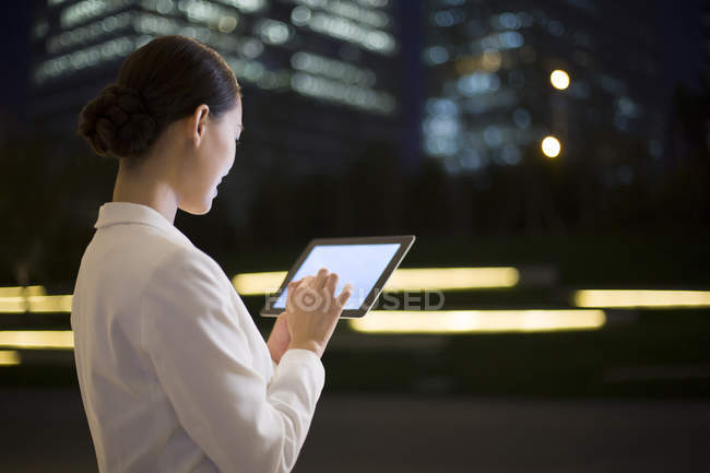 Donna d'affari cinese utilizzando tablet digitale, vista posteriore — Foto stock
