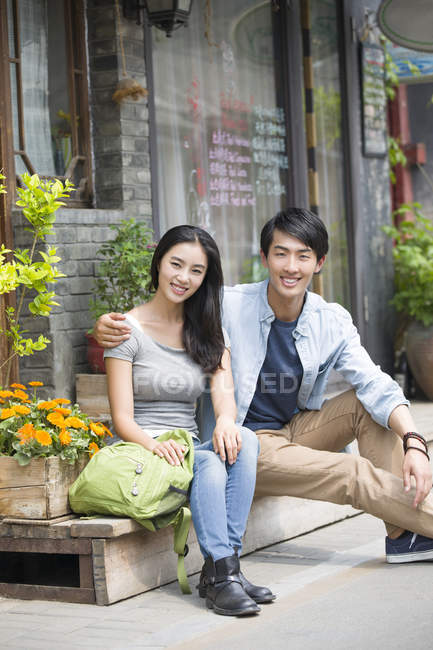 Chinese couple of tourists resting on street — Stock Photo