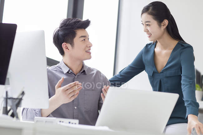 Chinese business co-workers talking in office — Stock Photo