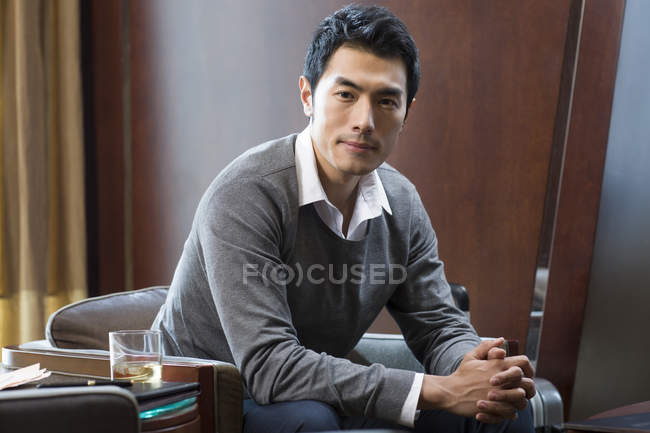 Retrato de empresario chino pensativo en habitación de hotel - foto de stock