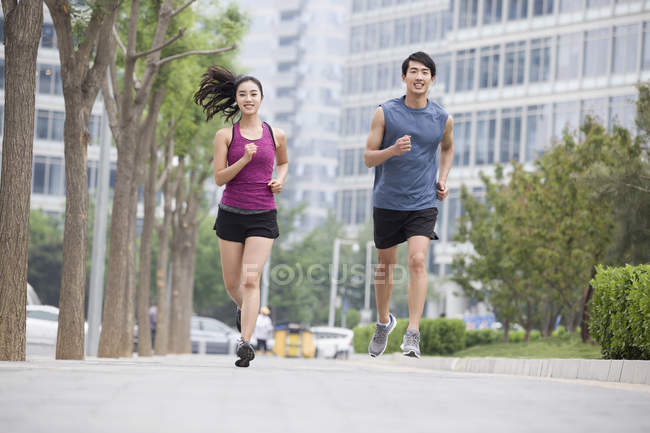 Casal chinês correndo juntos na rua — Fotografia de Stock