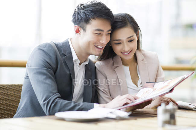 Китайская пара читает меню в ресторане — стоковое фото