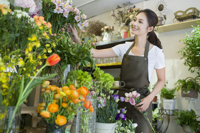 Femmina asiatico fiorista working in flower shop — Foto stock