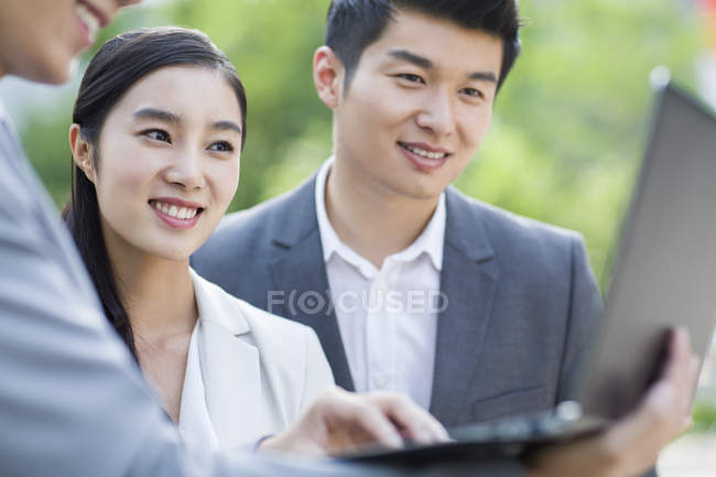 Chinese business people working with laptop at street — Stock Photo